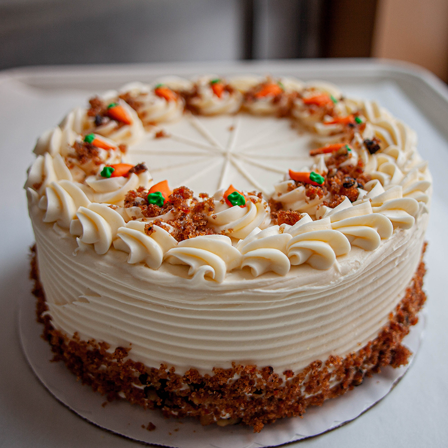 A round cake with decorative carrots. 
