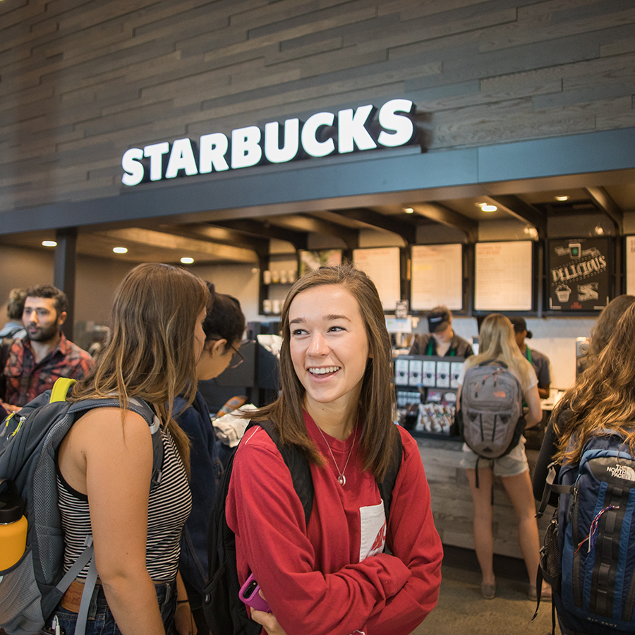 Girl smiling in front of Starbucks